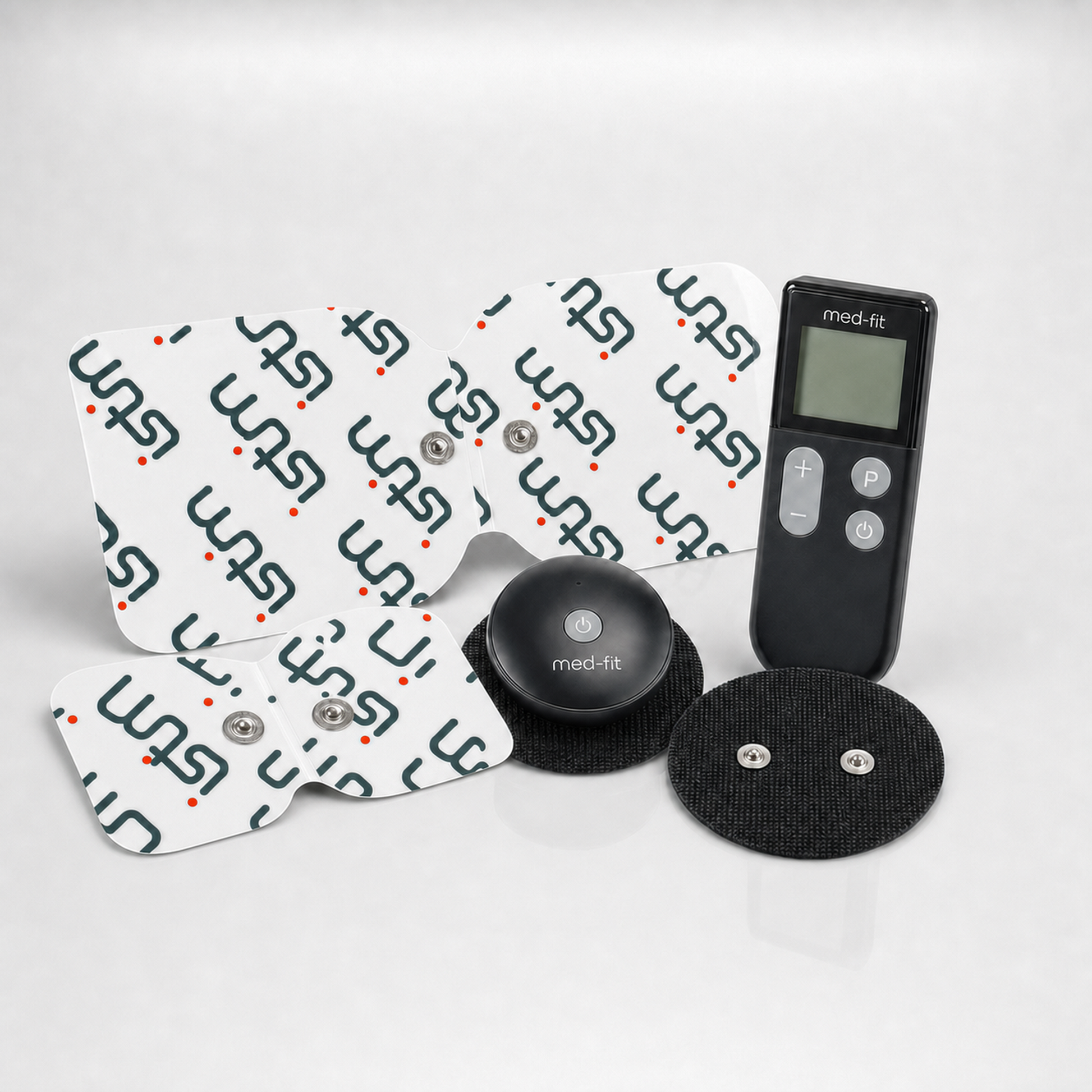 A med-fit TENS unit muscle stimulator kit with four white electrode pads printed with the med-fit logo, a black round controller, and two black adhesive gel pads on a light gray reflective surface.